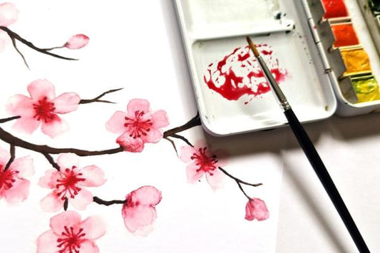 a watercolor painting of japanese cherry blossoms with a brush and watercolor on a white background