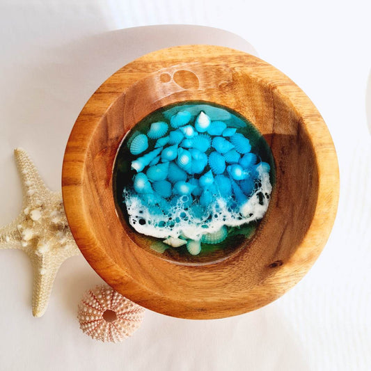 wooden bowl with resin ocean art and shells inside on a white background