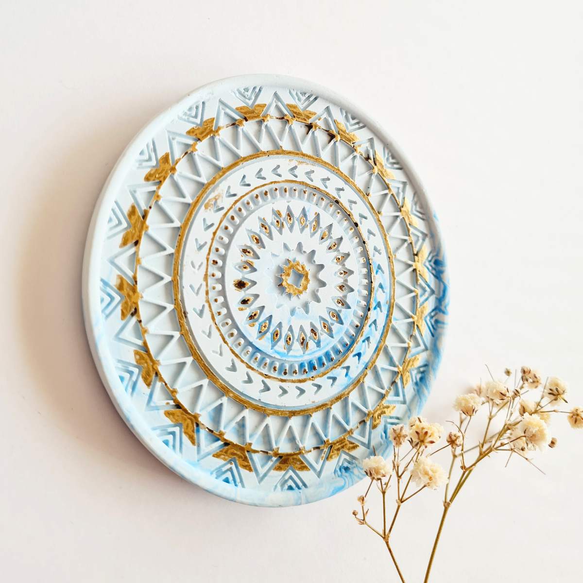 Blue and gold mandala ring dish on a white background