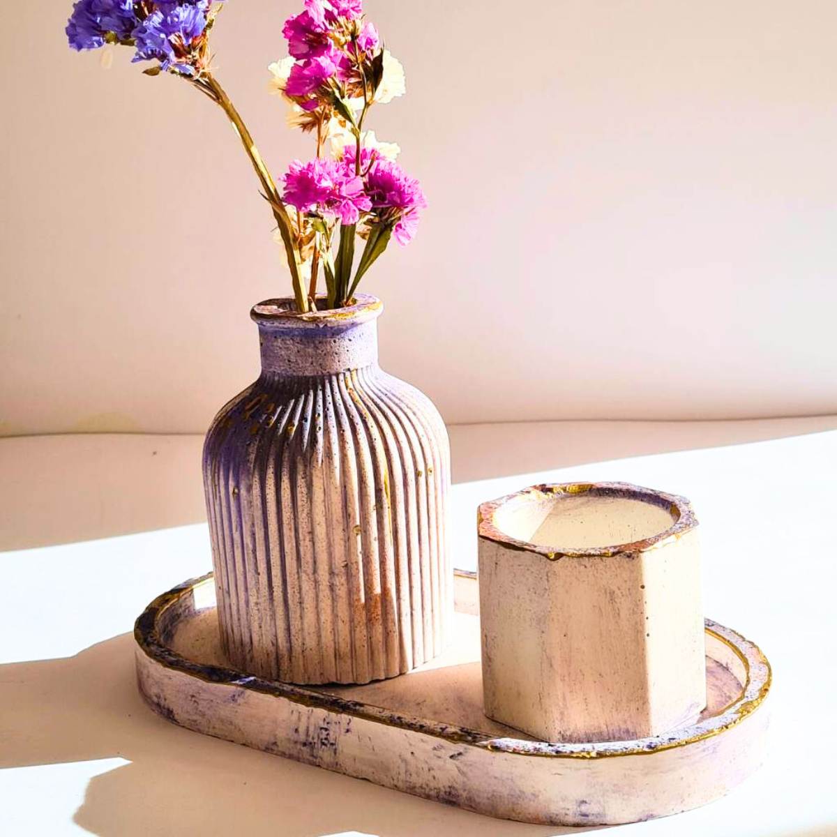 a purple and white vase a decorative tray and a candle holder on a white background