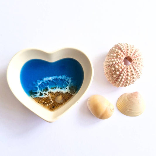 small white heart ring dish with blue ocean resin art on a white surface